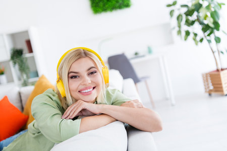 Photo of lovely positive good mood girl sitting comfy couch listening relaxing morning music enjoying weekend sweet homeの写真素材