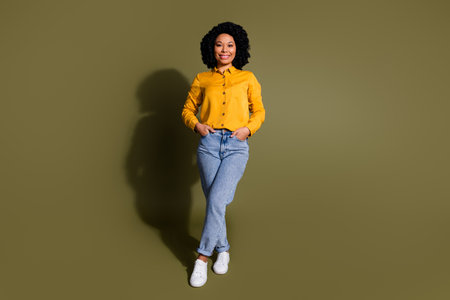 Full size photo of pretty lady posing empty space ad wear yellow shirt isolated on khaki color backgroundの写真素材