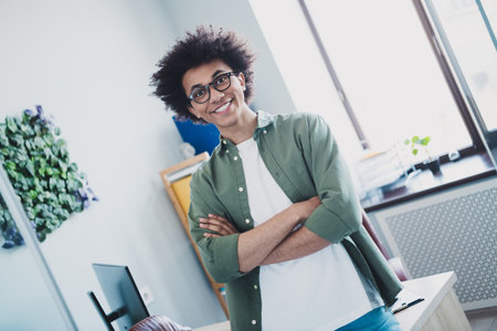 Photo of clever intelligent manager wear khaki shirt glasses indoors arms crossed workshop workplaceの写真素材