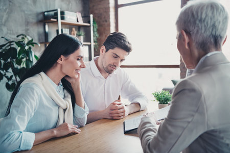 Photo of young married couple read clipboard appointment consultation psychotherapist lady office indoorsの写真素材