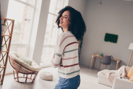 Photo of cheerful positive lady dressed striped pullover laughing arms crossed indoors apartment roomの写真素材