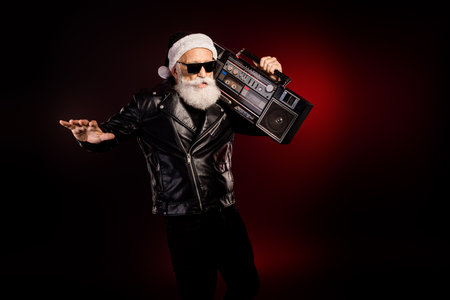 Cool santa rocker with leather jacket and boombox on stage showing festive energy for christmas...