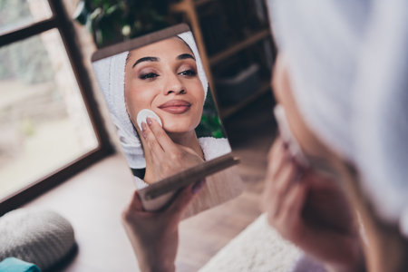 Photo portrait of pretty young girl apply tonic cotton disc look mirror head wrapped towel dressed bath robe beauty routine home conceptの写真素材