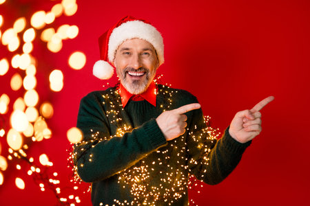 Cheerful santa man with twinkling lights wears a cozy sweater and spreads holiday joy for a festive christmas moodの写真素材