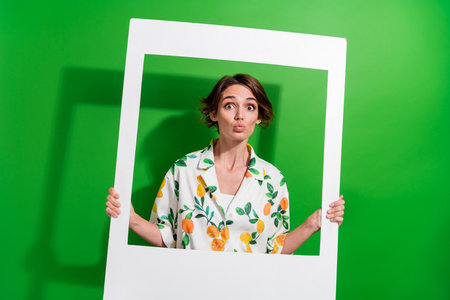 Photo of shiny flirty lady wear print shirt taking photo sending you kiss isolated green color...