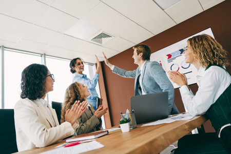 Business team celebrates success in modern office workspace with teamwork and collaboration