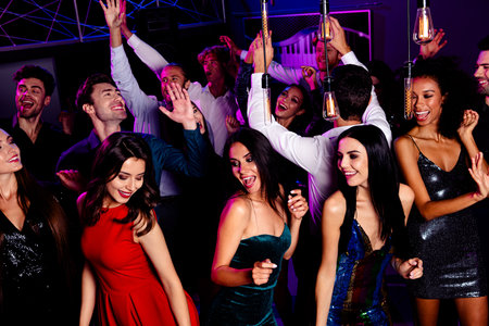 Dancers celebrate at a vibrant club party with friends dancing under neon lights and warm bulbs