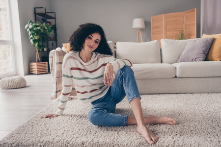 Photo portrait of attractive young woman sit floor enjoy comfort dressed casual clothes cozy day light home interior living roomの写真素材