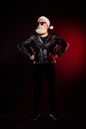 Cool Santa rocker in leather jacket with beard and sunglass posing in christmas themed portrait for holiday season and festive marketingの写真素材