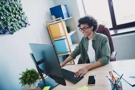 Photo of employee wear khaki shirt eyeglasses communicating indoors workstation workplace