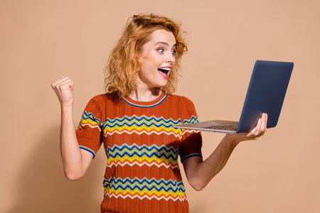 Photo portrait of lovely young lady hold netbook winning dressed stylish striped garment isolated on...