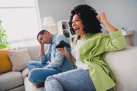 Photo of nice young man girl sit sofa play videogame modern interior indoors cozy daylight apartment living roomの写真素材