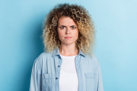 Photo of grumpy frustrated disappointed lady look camera grimace wear casual shirt isolated blue color backgroundの写真素材