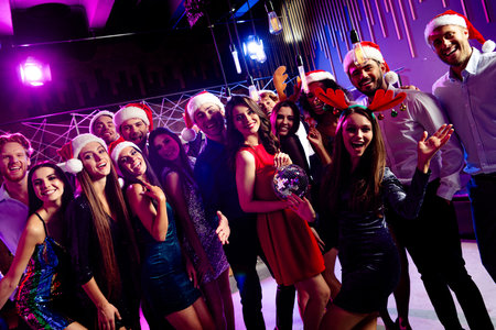 Fun filled Christmas party moment with friends dancing in a neon club scene at a festive holiday celebrationの写真素材