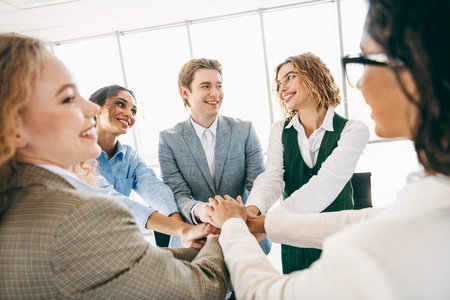 Confident coworkers building teamwork during a workplace meeting emphasizing collaboration, diversityの写真素材