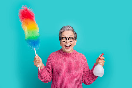 Portrait of impressed person wear knit pullover in eyewear hold dust cleaner spray in hands isolated...