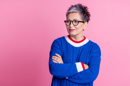 Photo of confident retired woman wear blue trendy clothes crossed arms look empty space isolated on pink color backgroundの写真素材