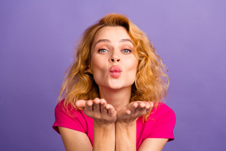 Photo of sweet shiny adorable woman wear stylish pink clothes send kiss isolated on purple color backgroundの写真素材