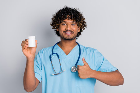 Photo of doctor guy hold bottle jar vitamins drugs isolated grey color backgroundの写真素材