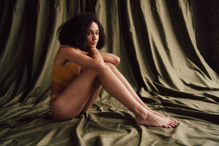 Unretouched photo of girl posing isolated green color studio backgroundの写真素材