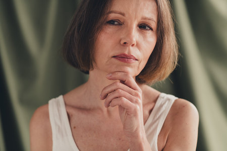Unretouched photo of attractive old lady feel thoughtful thinking look profile side isolated green color linen backgroundの写真素材