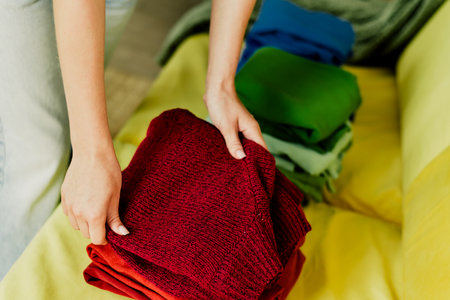 Arranging colorful fabrics on a bright living room sofa creates a warm home moment after a busy dayの写真素材