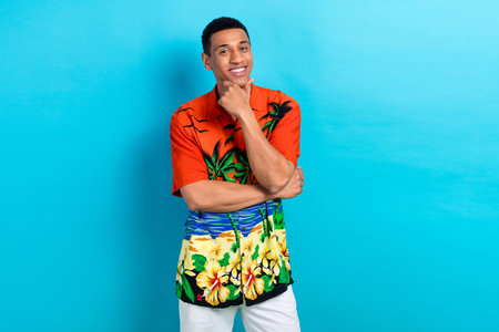 Photo of funky thoughtful guy dressed print shirt hand arm chin empty space isolated blue color...