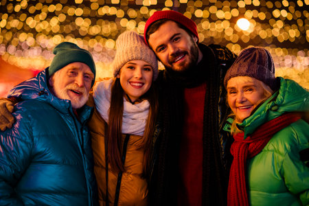 Funny festive night out with family and friends smiling under twinkling lights for a merry Christmas...