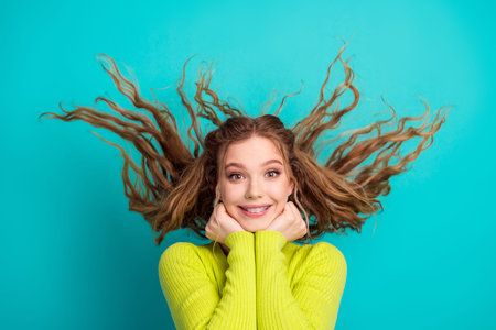 Bright and playful expression of woman with flowing tousled hair and modern fashion showcasing...