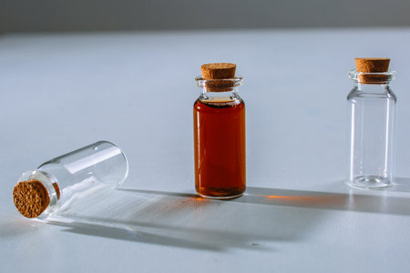 a test tube with a dark liquid stands next to the test tubes with a light liquidの写真素材