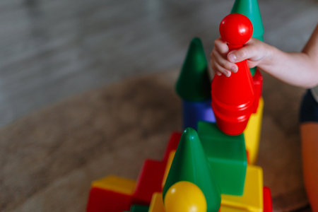 Colored children's toys, a boy's hand holding a pin