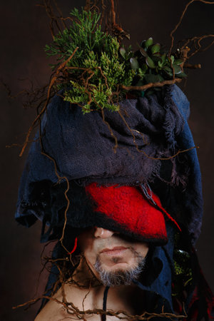 A man with a felt-plant decoration on his head.の写真素材