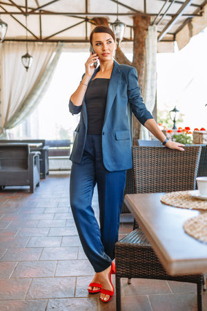 Business girl in a blue suit, resting in a restaurantの写真素材