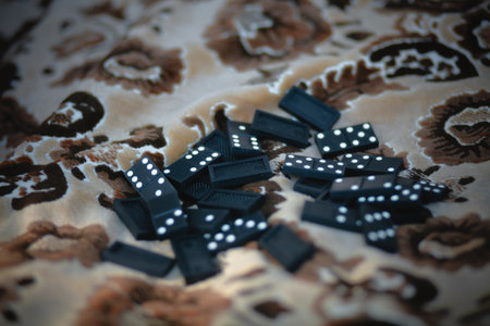 Black dominoes lying on a beige blanket