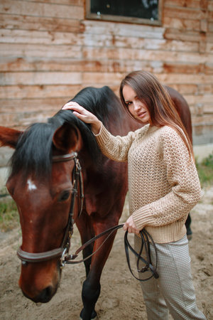 Girl rider standing next to a horseの写真素材