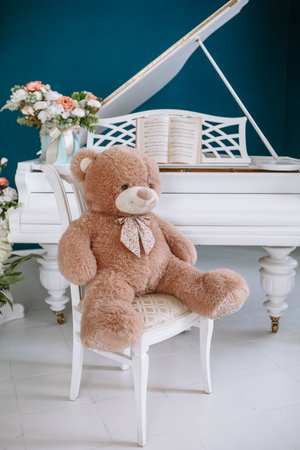 A teddy bear lying on a shelf next to a red alarm clock. wooden wallsの写真素材