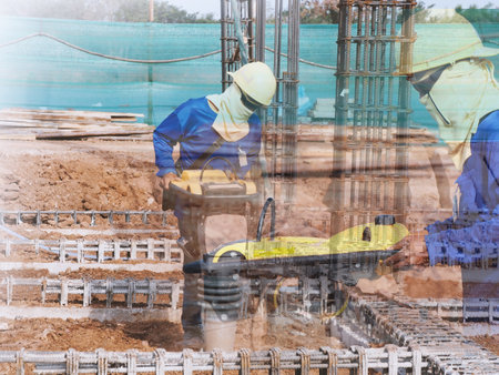 Construction worker compacting soil in house foundation using compactor