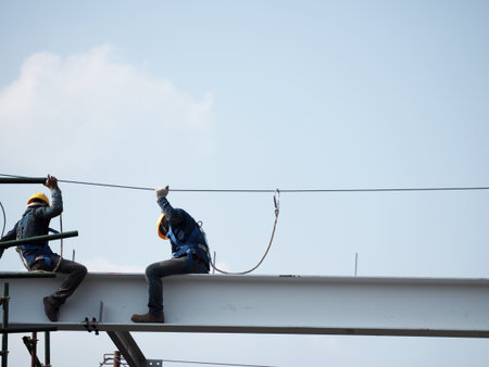 Man Working on the Working at height on construction site with blue skyのeditorial素材