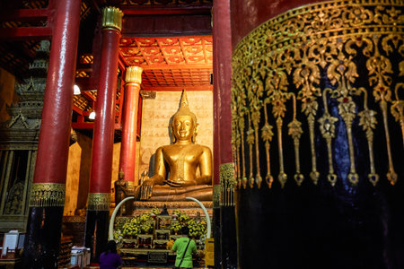 Old antique statue of Buddha in a temple room. Thailandのeditorial素材