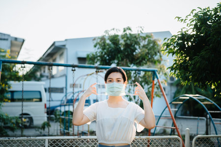 Demonstration to wearing a surgical mask at outdoor, Asian woman protect  the virus Covid-19 pandemic, stay safety and social distancing concept for protect from Corona virusの写真素材