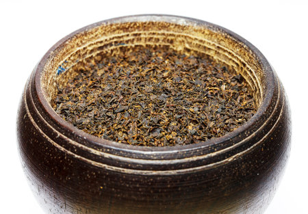 Black tea isolated on white in wooden bowl