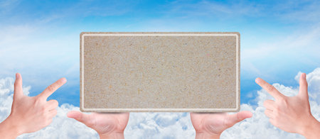 hand holding empty recycle paper with blue sky background の写真素材