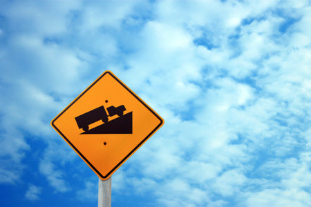 Warning sign steep on the clouds and blue sky background 
