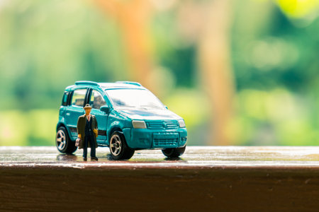 Business figure and toy car on wooden terraceの写真素材