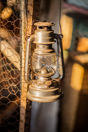 Antique oil lamp hanging on an old metal fence の写真素材