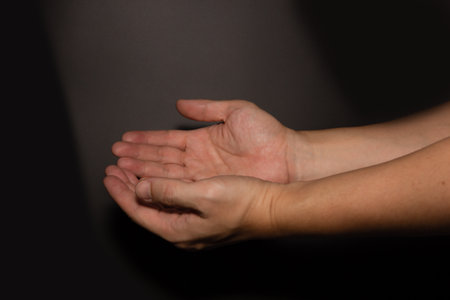 The man whose hand is praying on the dark background,selective focus.の写真素材