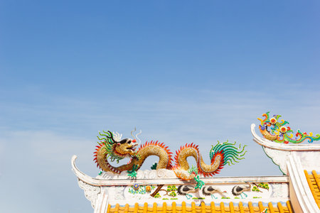 golden Chinese stucco art on the roof of a Chinese temple on the sky backgroundの写真素材