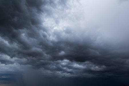 The dark sky had clouds gathered to the left and a strong storm before it rained.