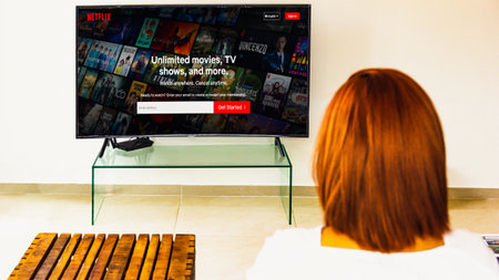 Prachuap Khiri Khan ,THAILAND - April 13, 2021: Behind the scenes of a woman in a white dress with red hair watching netflix. in the living room.のeditorial素材