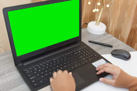 woman working online on laptop computer with green screen for content mockup. Concept of working...